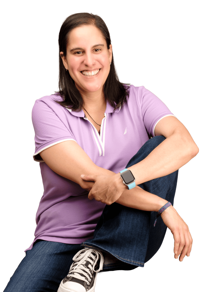 Candy sentada, sonriendo, con playera morada.